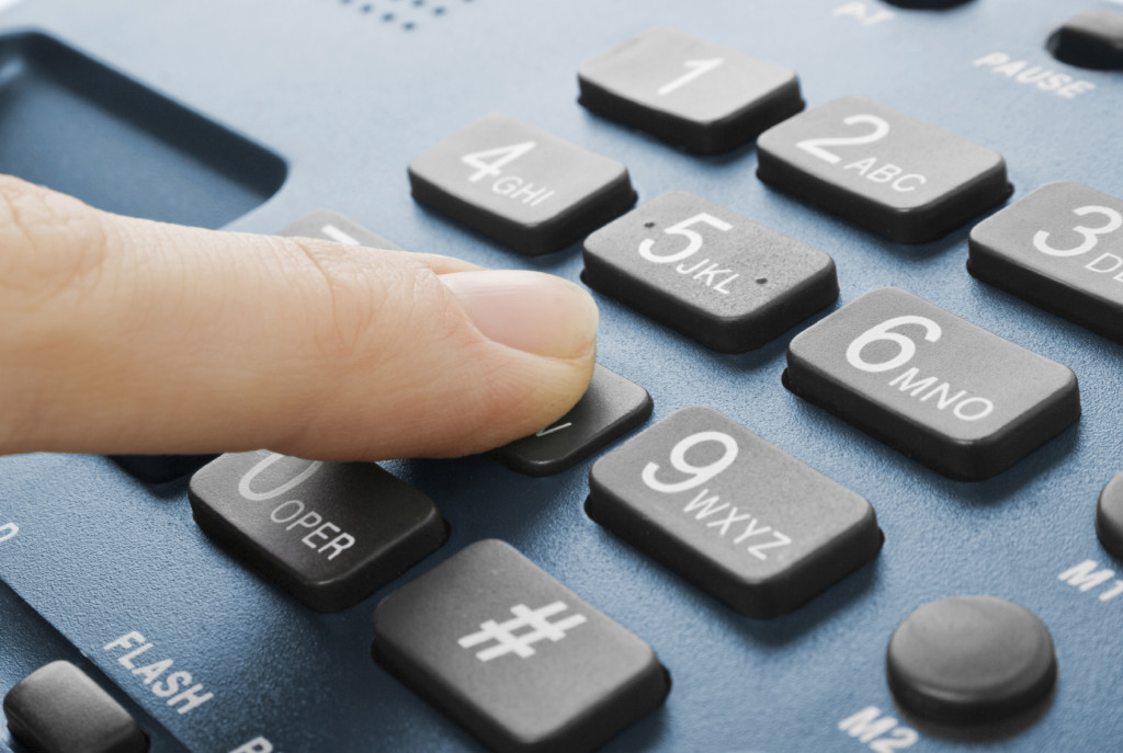 office black telephone with hand isolated on white